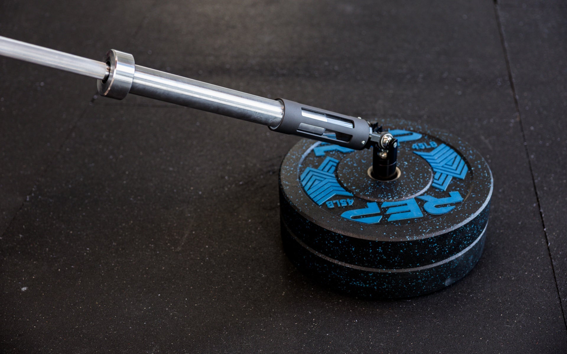 A barbell being slid into the polycarbonate sleeve of the Free Standing REP® x Kleva Built® Adroit Landmine