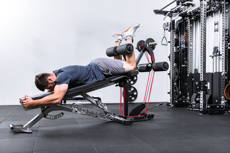 Athlete using resistance bands, weight plates, and cable resistance on the Leg Extension & Leg Curl Bench Attachment