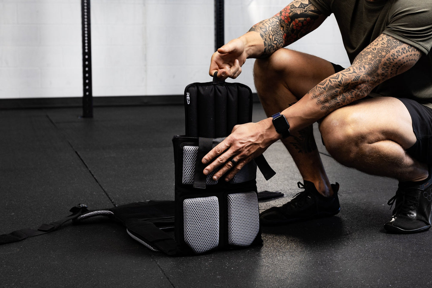 Person inserting soft weight vest plate into the weight vest.